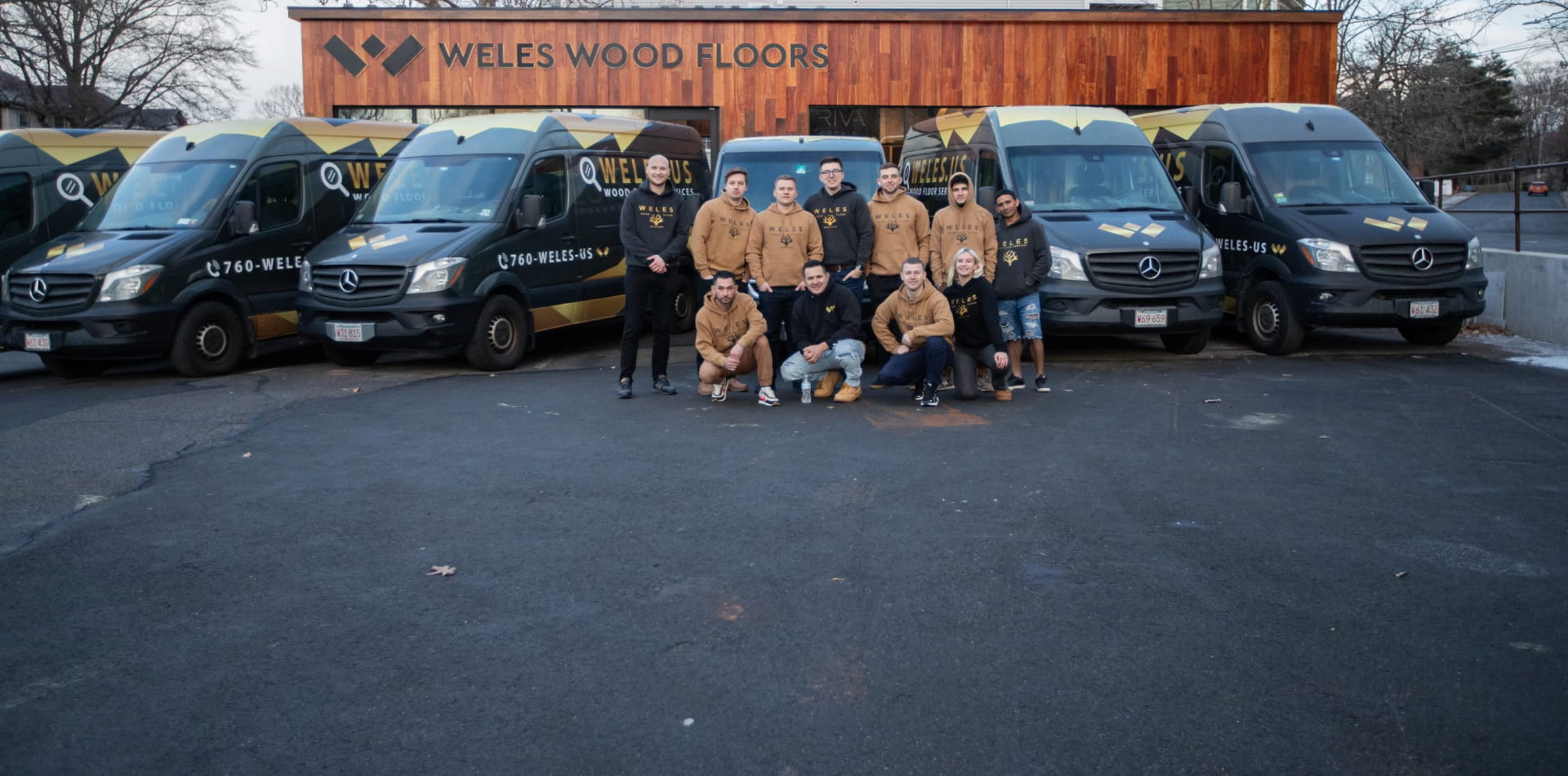 Weles Wood Floors team in front of their branded vans