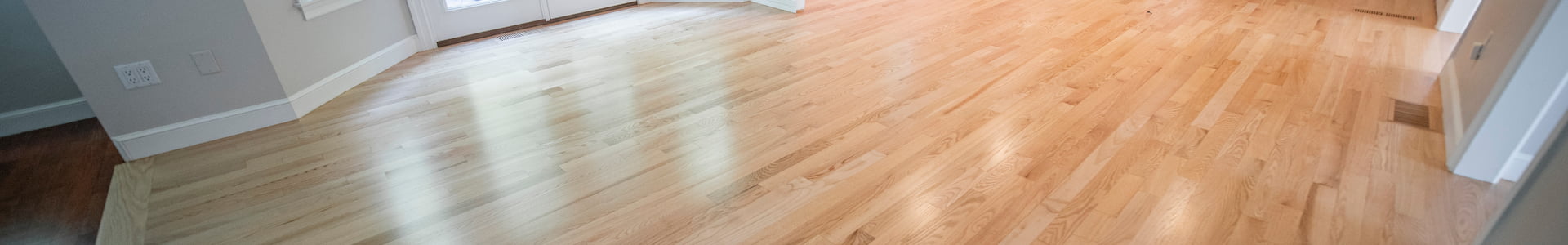 Panoramic view of a residential room with a newly installed light hardwood floor by Weles, displaying a smooth, natural wood texture and quality craftsmanship, enhancing the room’s bright and inviting atmosphere.